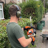 Landscaper wearing 24dB folding ear defenders and PPE gloves while using a petrol hedge trimmer