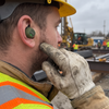 Close-up of a construction worker wearing an M20 electronic in-ear hearing protection earbud, PPE gloves and hard hat